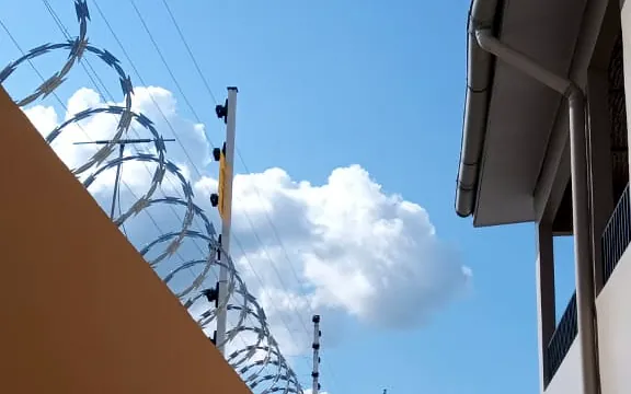 Concertina galvanizada instalada sobre muro com cerca elétrica
